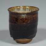 Yunomi/tea cup with ame glaze exterior and madara glaze interior.