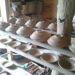 stacked, trimmed pots drying w/ new pots below.
